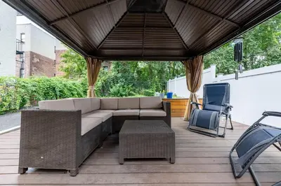 a patio with a couch and awning at Massive NYC House with Pool Table in Yonkers
