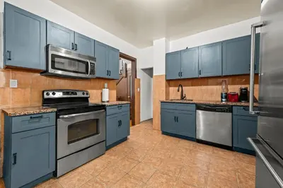 a kitchen with blue cabinets and stainless steel appliances at Massive NYC House with Pool Table in Yonkers