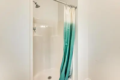 a shower with a blue shower curtain in a bathroom at 2 Mi to The Mark Twain House and Museum Airy Escape in West Hartford