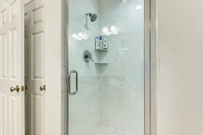 a bathroom with a shower with a glass door at 2 Mi to The Mark Twain House and Museum Airy Escape in West Hartford
