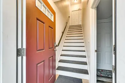 a hallway with stairs and a red door at 2 Mi to The Mark Twain House and Museum Airy Escape in West Hartford