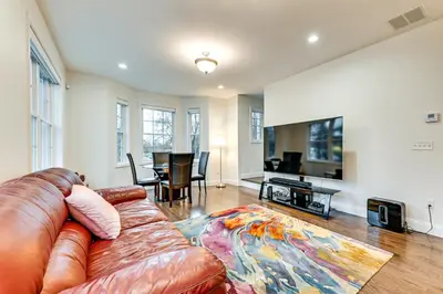 a living room with a leather couch and a table at 2 Mi to The Mark Twain House and Museum Airy Escape in West Hartford