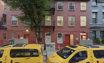 two yellow taxis parked in front of a building at Minimalist Midtown West Studio in Central Manhattan in New York