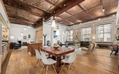 a living room with a wooden table and white chairs at Sun-Filled Luxury Historic 2 Bedrooms apto in New York