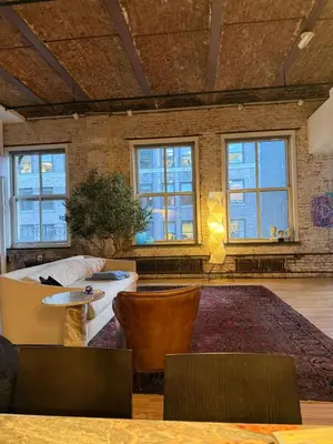 a living room with a couch and tables and windows at Sun-Filled Luxury Historic 2 Bedrooms apto in New York