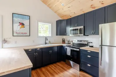a kitchen with black cabinets and a refrigerator at Berkshire House in Hillsdale