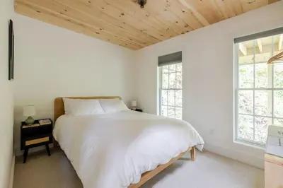 a white bedroom with a large bed and windows at Berkshire House in Hillsdale
