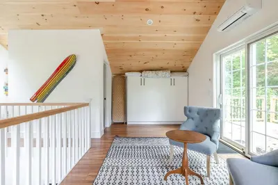 a living room with a blue chair and a table at Berkshire House in Hillsdale
