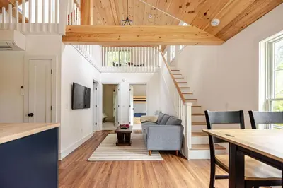 a living room with white walls and wooden ceilings at Berkshire House in Hillsdale