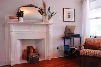 a living room with a white fireplace with a mirror at Hot Tub, 2 Blocks to Downtown Saugerties, Sleeps 8 in Saugerties