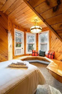 a bedroom with a large bed in a room with windows at Mansion of Belleayre Mountain! POOL, SAUNA, Game Room in Fleischmanns