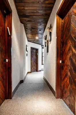 an empty hallway with wooden ceilings and a door at Mansion of Belleayre Mountain! POOL, SAUNA, Game Room in Fleischmanns