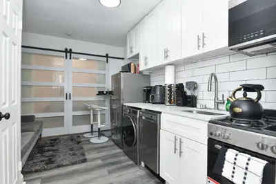 a kitchen with white cabinets and a stove top oven at Cozy 1BR in Central Manhattan W Private Terrace in New York