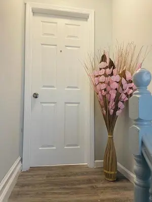 a vase with pink flowers in front of a door at Xceptional homes in East Orange