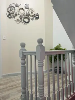 a staircase with a railing and a plant in a room at Xceptional homes in East Orange