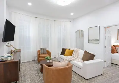 a living room with a white couch and chairs at The Harper Loft in Hoboken