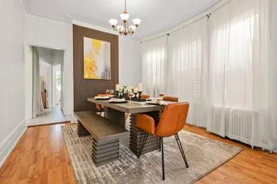 a dining room with a table with orange chairs at The Caleb Loft in Hoboken