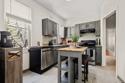 a kitchen with stainless steel appliances and a table at The Caleb Loft in Hoboken
