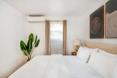 a white bedroom with a white bed and a window at 26-1C Gramercy Large 1BR WD in New York