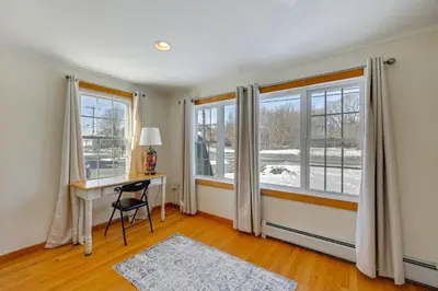 a home office with a desk and windows at Heart of Five College Consortium! Hadley Home in Hadley
