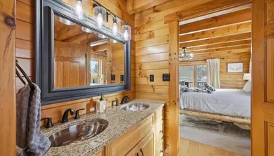 a log cabin bathroom with two sinks and a bed at Amazing Views Hot Tub Fire Pit Game Room in Ashland