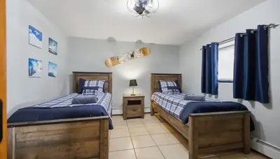 two twin beds in a room with blue curtains at Amazing Views Hot Tub Fire Pit Game Room in Ashland