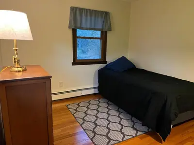 a bedroom with a bed and a table with a lamp at Perfect Family Retreat in East Haven in East Haven