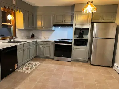 a kitchen with white cabinets and black appliances at Perfect Family Retreat in East Haven in East Haven