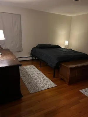 a bedroom with a bed and a table and two rugs at Perfect Family Retreat in East Haven in East Haven