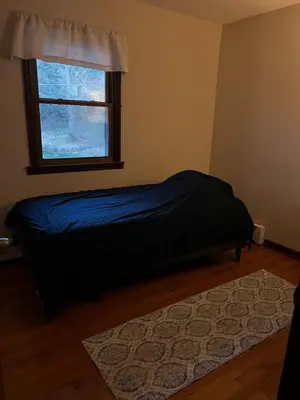 a bedroom with a bed with a window and a rug at Perfect Family Retreat in East Haven in East Haven