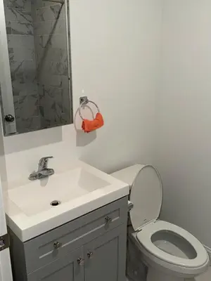 a bathroom with a white sink and a toilet at Exclusive Home in Newark