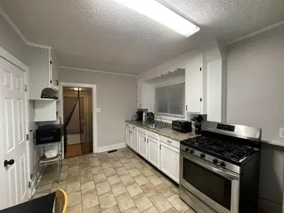 a kitchen with white cabinets and a stove top oven at Beach Apartment in Woodmont Milford 102 in Milford