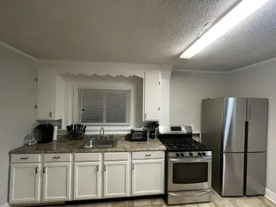 a kitchen with white cabinets and a stainless steel refrigerator at Beach Apartment in Woodmont Milford 102 in Milford