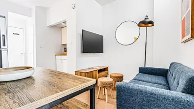 a living room with a blue couch and a table at Monthly Furnished 2BD in Hudson Yard, Manhattan, NYC! in New York