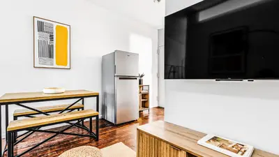 a kitchen with a stainless steel refrigerator and a table at Monthly Furnished 2BD in Hudson Yard, Manhattan, NYC! in New York
