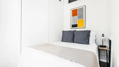 a white room with a bed with a white wall at Monthly Furnished 2BD in Hudson Yard, Manhattan, NYC! in New York