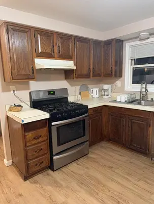 a kitchen with wooden cabinets and a stove top oven at FOR LONGTERM RENTAL 3 BR NEAR YALE SCIENCE CENTER-MUNSON St in New Haven