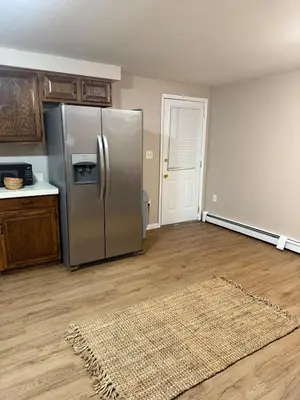 a kitchen with a stainless steel refrigerator and a rug at FOR LONGTERM RENTAL 3 BR NEAR YALE SCIENCE CENTER-MUNSON St in New Haven