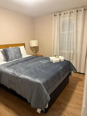 a bedroom with a bed with a blue blanket and a window at FOR LONGTERM RENTAL 3 BR NEAR YALE SCIENCE CENTER-MUNSON St in New Haven