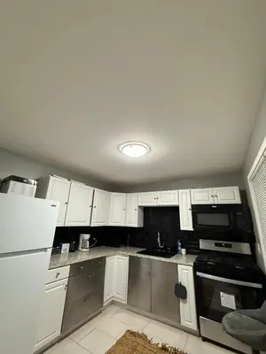 a kitchen with white cabinets and a white refrigerator at Barnes Avenue near Yale in New Haven