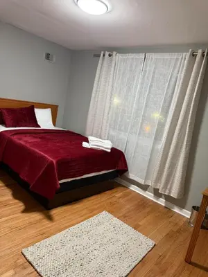 a bedroom with a red bed and a window at Barnes Avenue near Yale in New Haven