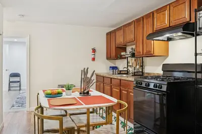 a kitchen with wooden cabinets and a table and a stove at Heaven in Newark