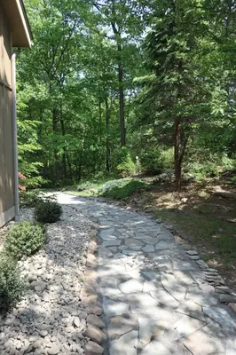 a cobblestone path in a garden with trees at Cozy 4bd 4bath Grand Cabin Retreat in Camelback in Tannersville