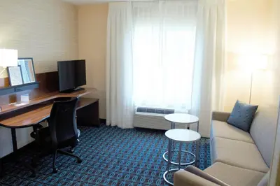 a hotel room with a couch and a desk with a computer at Fairfield Inn & Suites by Marriott Stroudsburg Bartonsville/Poconos in Stroudsburg