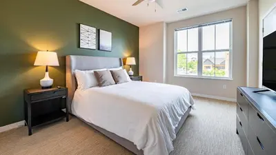 a bedroom with a white bed and a window at Landing Apartments - The Preserve at Great Pond in Windsor