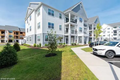 a white car parked in front of a building at Landing Apartments - The Preserve at Great Pond in Windsor
