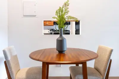 a vase on a wooden table with two chairs at Landing Stylish 1BD Courtyard in Springfield