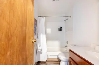 a white bathroom with a toilet and a sink at Landing Stylish 1BD Courtyard in Springfield
