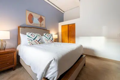 a bedroom with a large white bed and a wooden cabinet at Landing Stylish 1BD Courtyard in Springfield