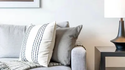 a pillow sitting on a couch next to a lamp at Landing Apartments - Park South in Albany